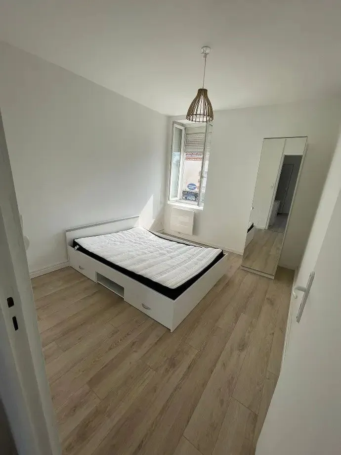 Chambre avec lit double, suspension et sol stratifié clair.