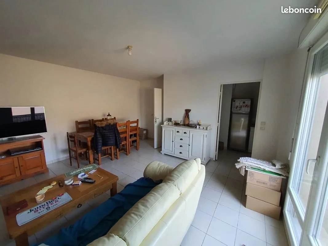 Séjour encombré de meubles et de cartons avant l'état des lieux.