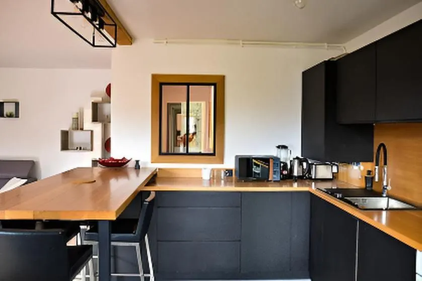 Appartement rénové détenu par Ornella Poulain. Séjour et cuisine ouverte, après travaux.