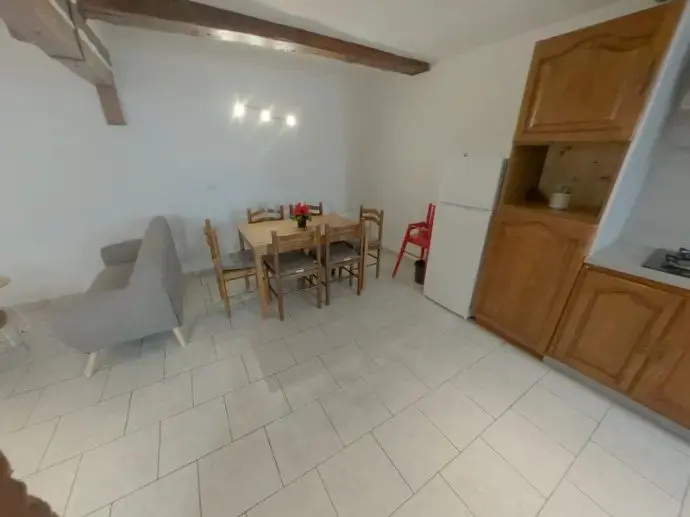 Cuisine refaite et espace repas après travaux, réfrigérateur et rangements neufs.