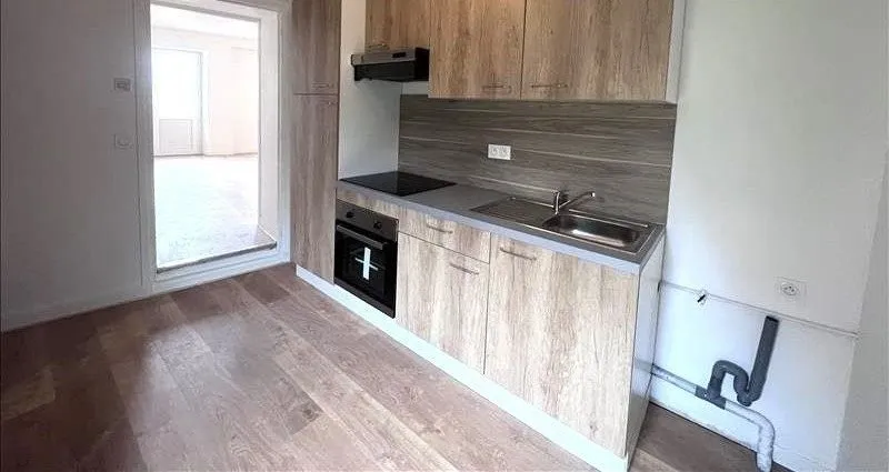 La cuisine équipée vue depuis le salon, sol stratifié.