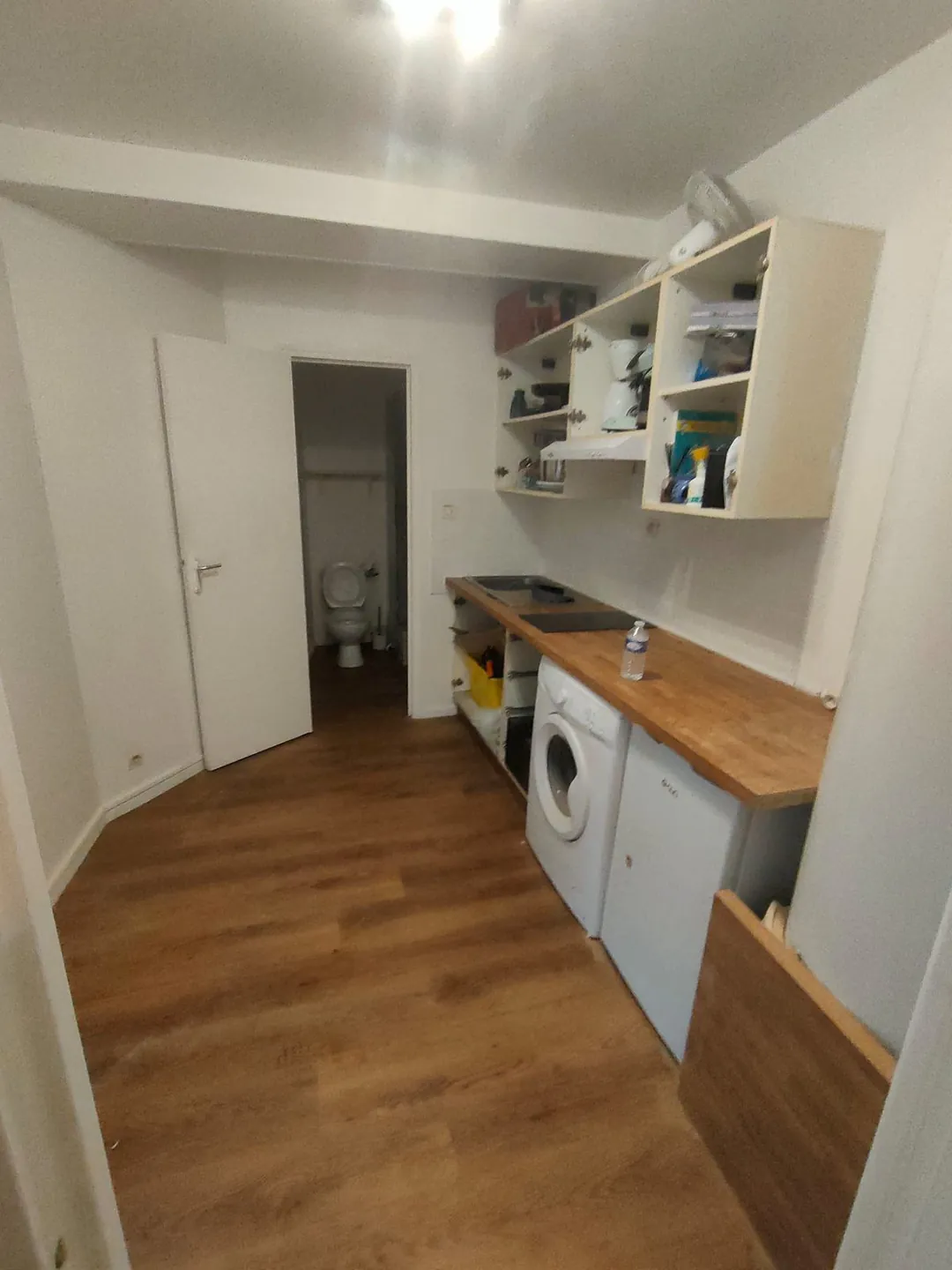 La cuisine en enfilade, porte de la salle d'eau ouverte au fond.