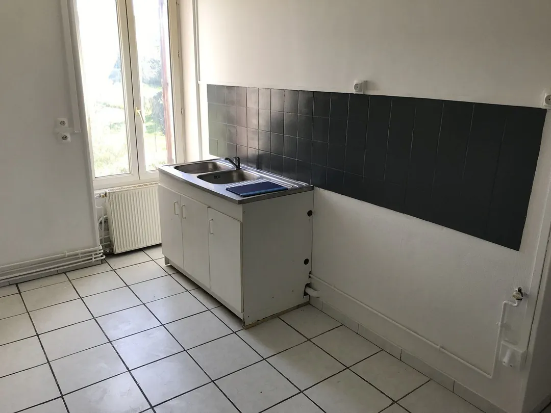 Cuisine d'origine : plan de travail carrelé le long du mur, sol en carrelage clair.