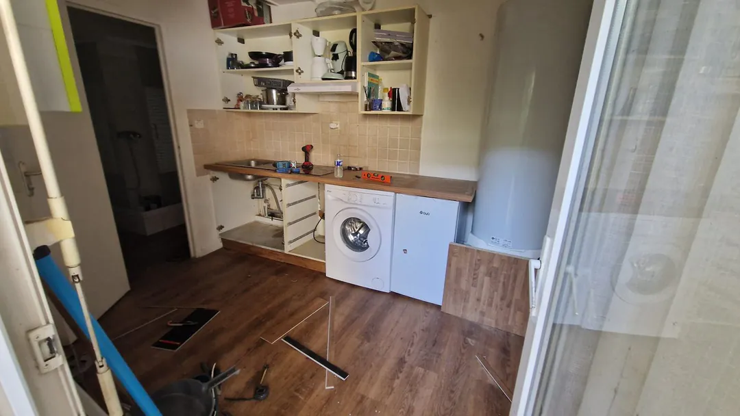 Nouveau plan de travail en bois posé, outils au sol sur le parquet neuf.