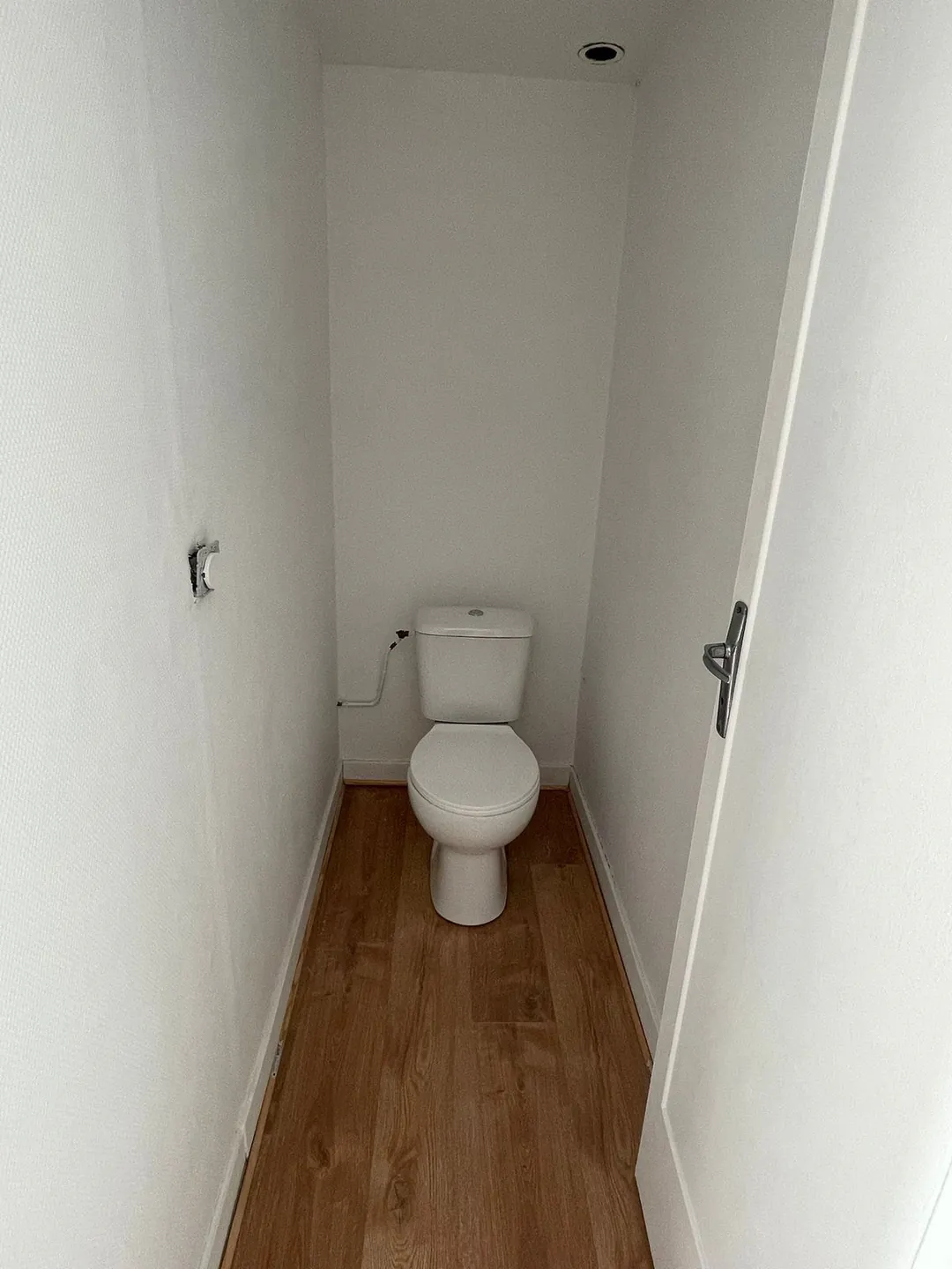 WC neuf posé, sol stratifié et cloison en plaques de plâtre.