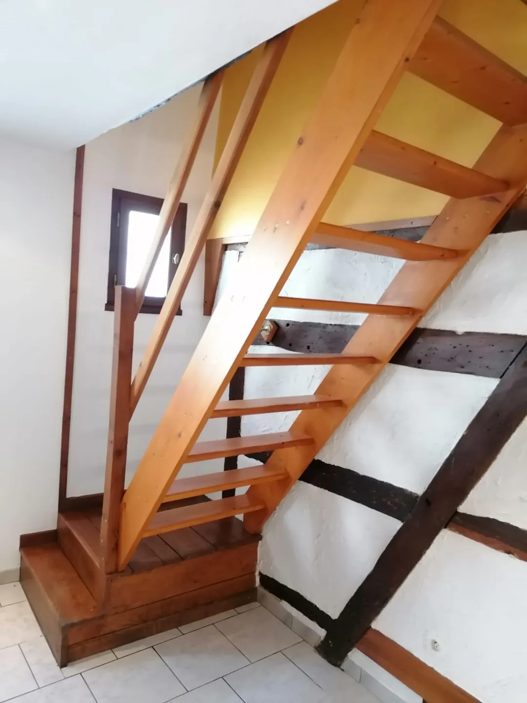 Escalier bois d'origine avec sa rampe, monté contre le mur à colombages.