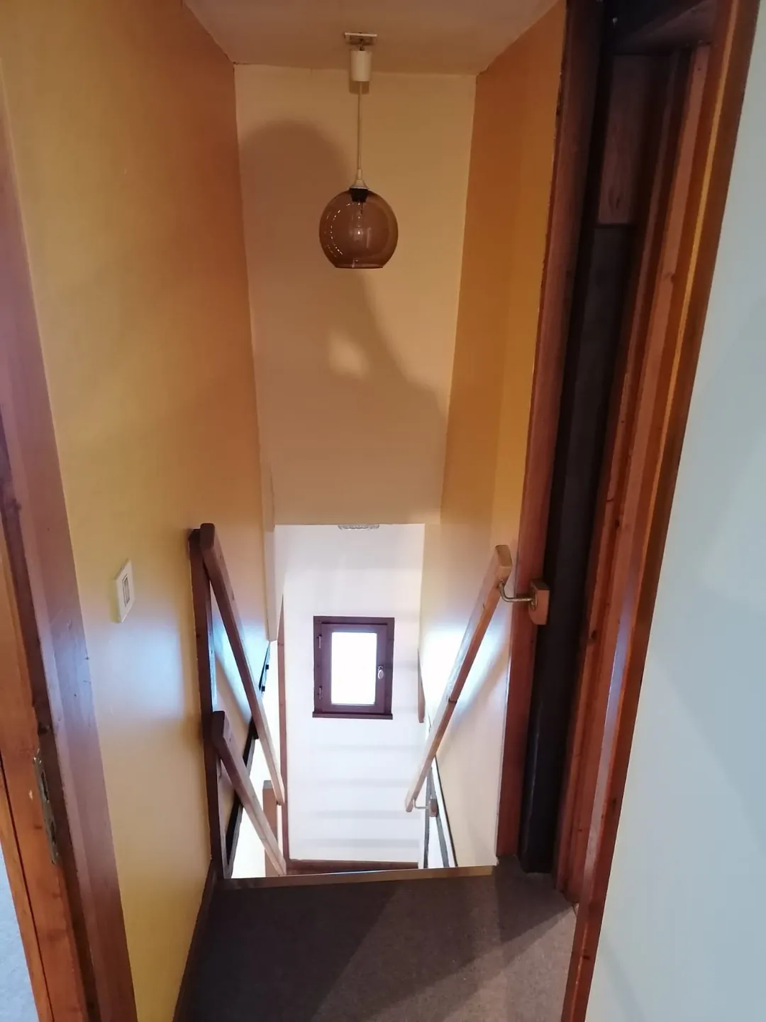 Le palier de l'étage, porte ouverte sur la cage d'escalier.