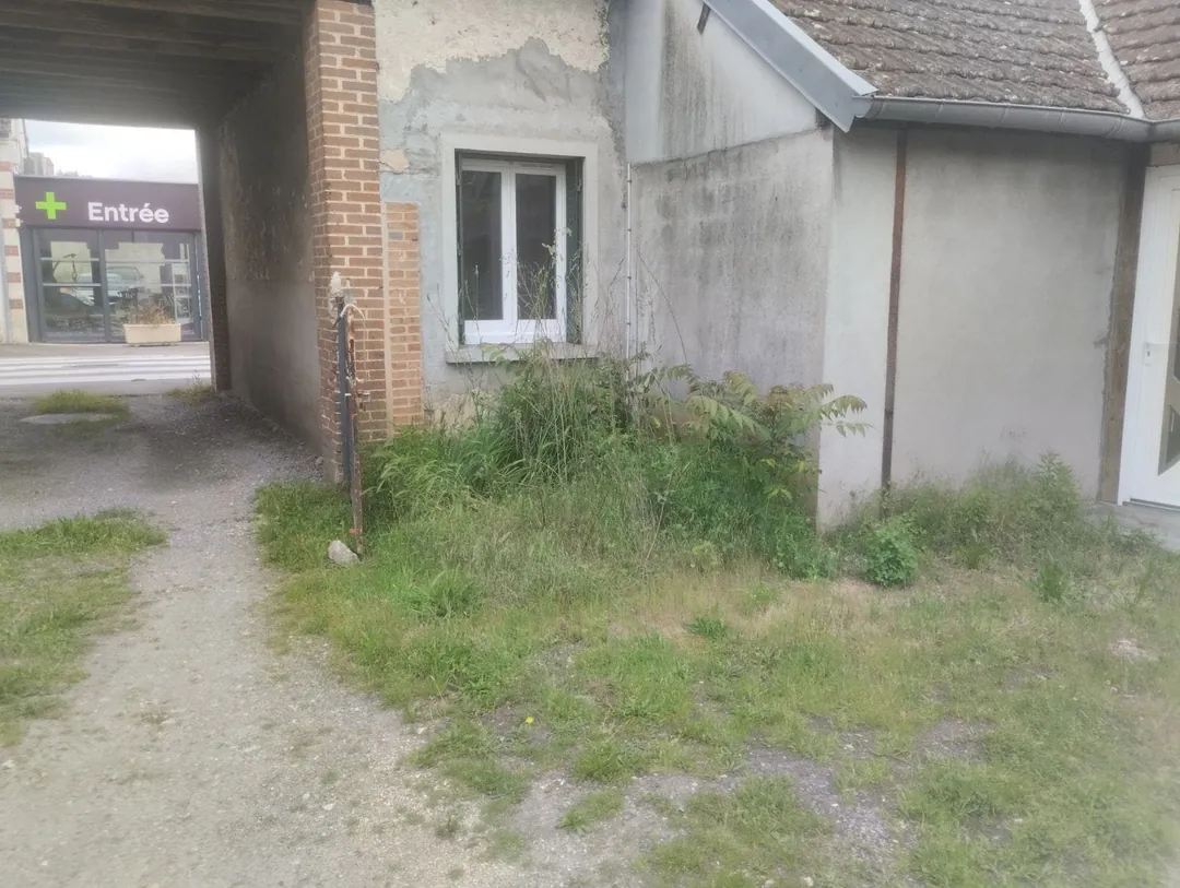 Mur de brique et fenêtre côté cour, allée en terre.