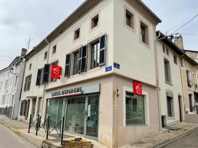 Immeuble d'angle avec commerce en rez-de-chaussée et deux niveaux au-dessus.