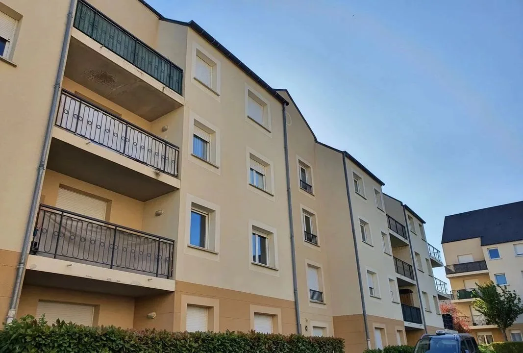 Immeuble de trois étages avec balcons, vu depuis la rue.