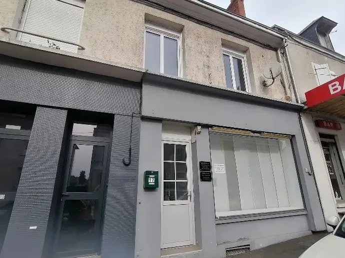 Façade d'immeuble avec une vitrine de local professionnel en rez-de-chaussée.