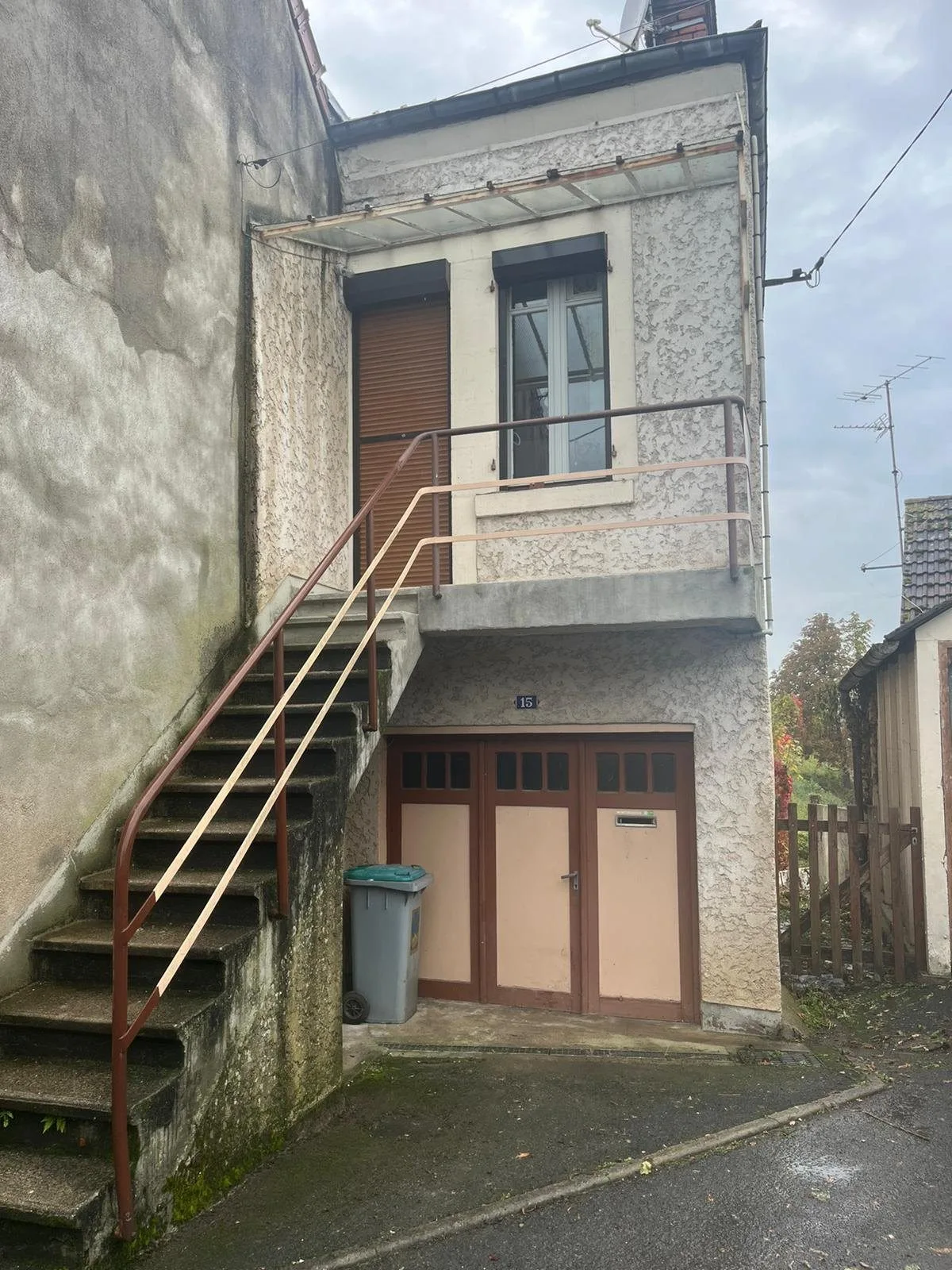 Maison avec escalier extérieur, garage et box en rez-de-chaussée.