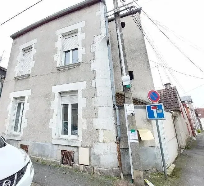 Maison de ville en pierre à deux niveaux, à l'angle de deux rues.