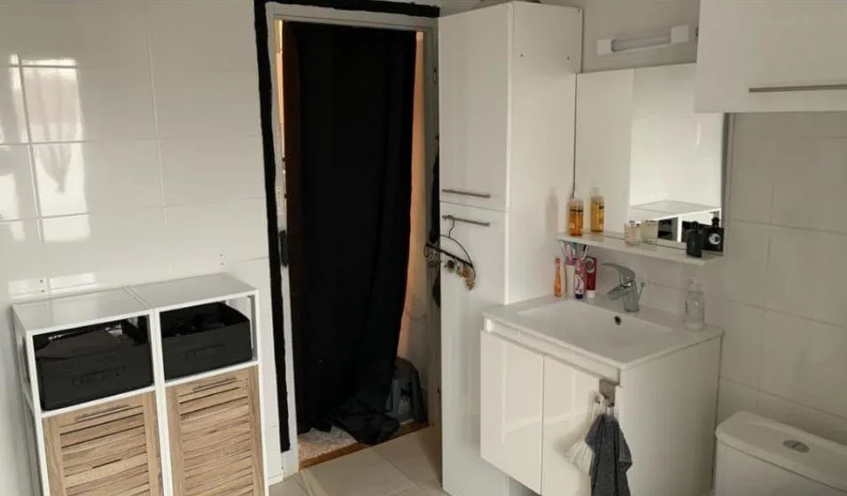Buanderie avec lave-linge, lavabo et rangements en osier.