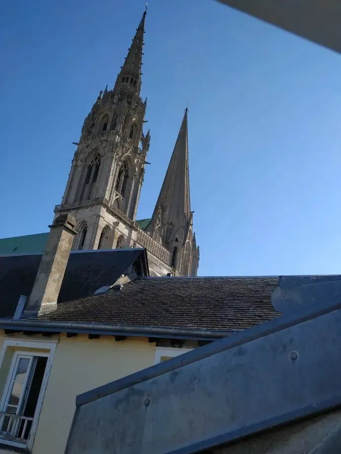 Flèche de cathédrale gothique vue depuis une fenêtre de toit.