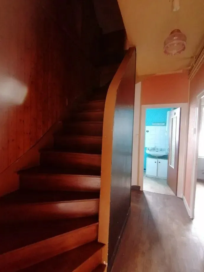 Escalier en bois peint rouge desservant l'étage.