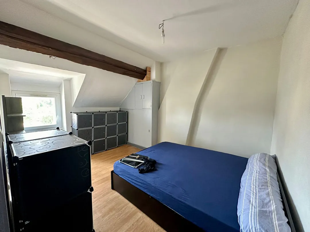 La chambre vue depuis la porte, lit double et rangements.