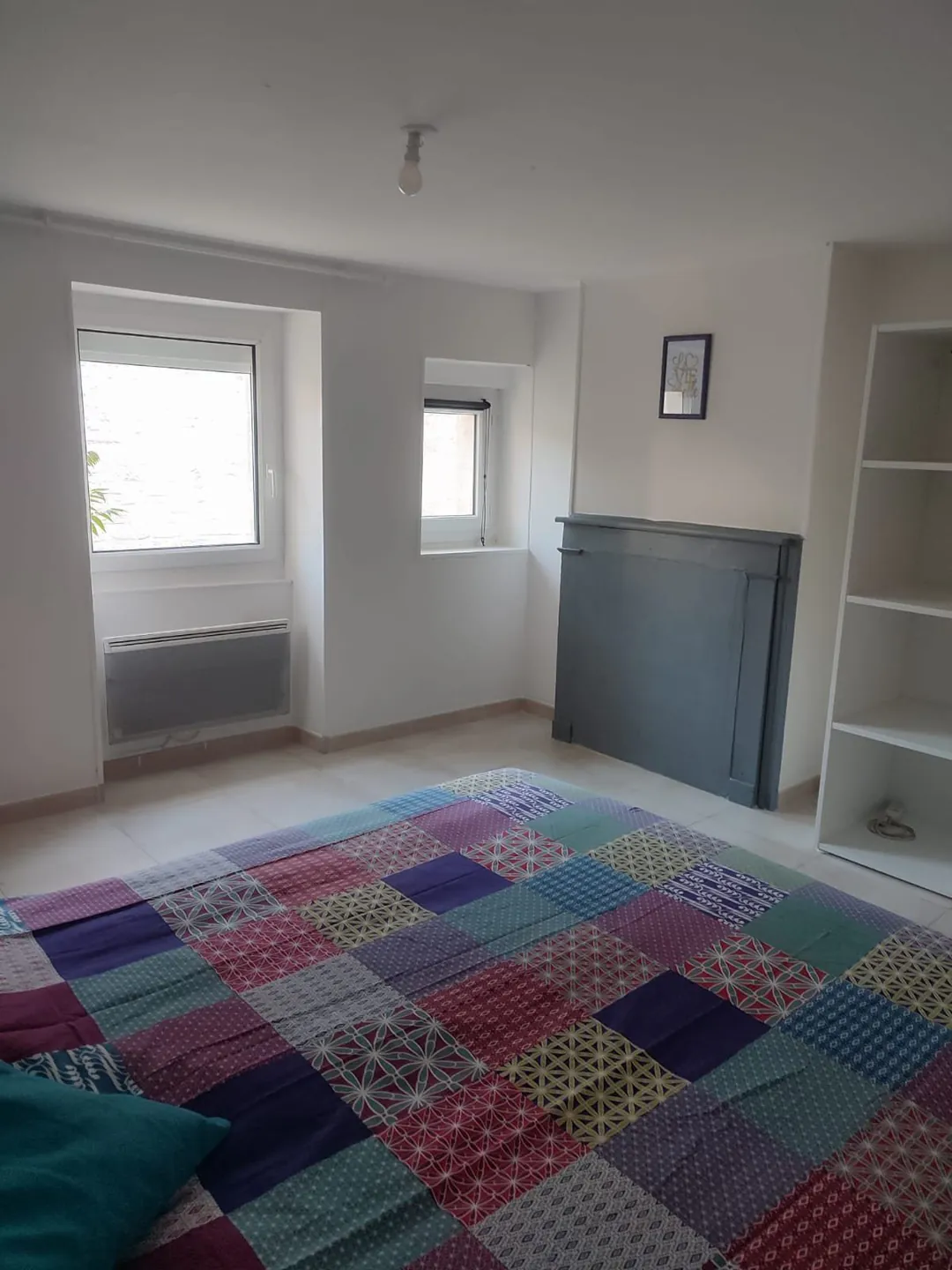 Vue plongeante sur le lit et le sol carrelé de la chambre.