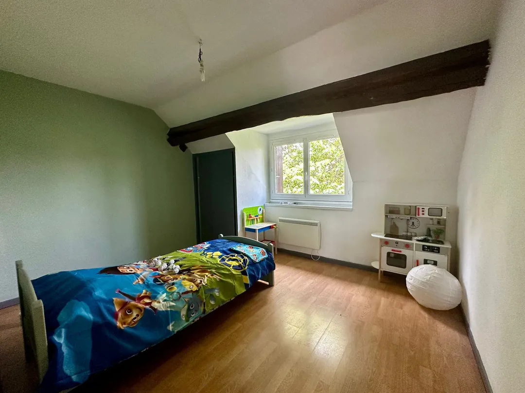 Seconde chambre, mur vert d'eau, lit simple et parquet.
