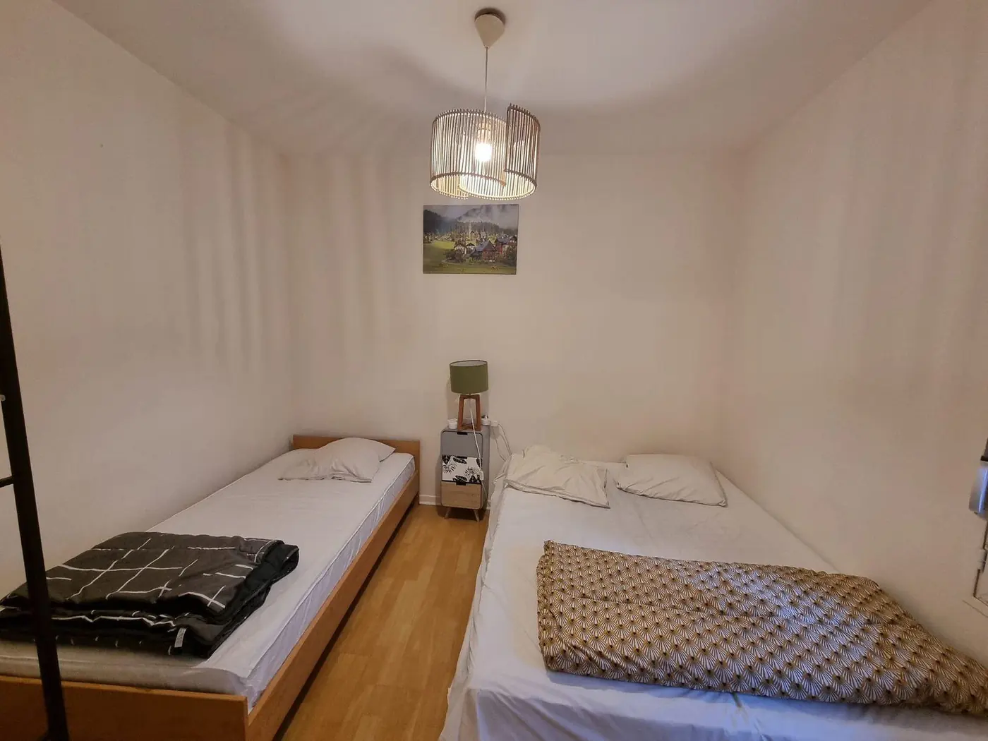Coin nuit d'origine : deux couchages, suspension en verre, tableau au mur.