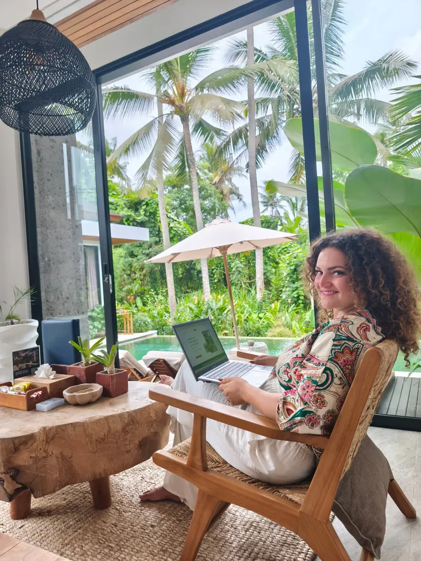 Ornella Poulain, fondatrice d'Ornella Invest, travaillant depuis l'étranger, ordinateur sur les genoux.