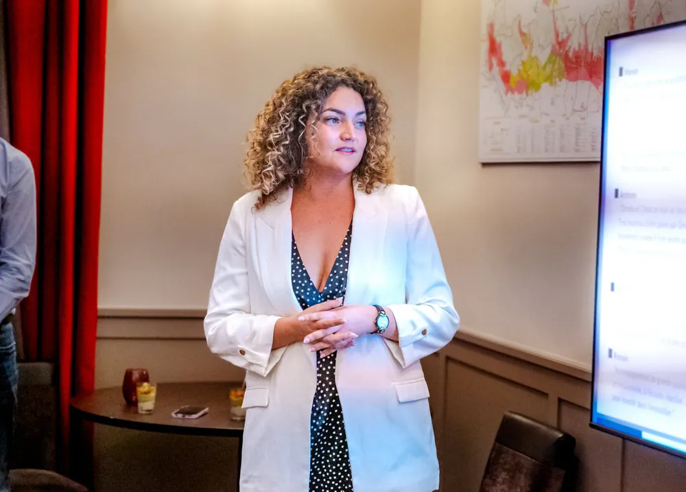 Ornella Poulain, fondatrice d'Ornella Invest, qui anime une rencontre devant un écran de présentation.