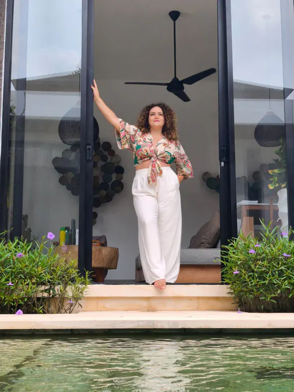 Ornella Poulain sur le seuil de sa villa à Bali, ouverte sur la piscine.