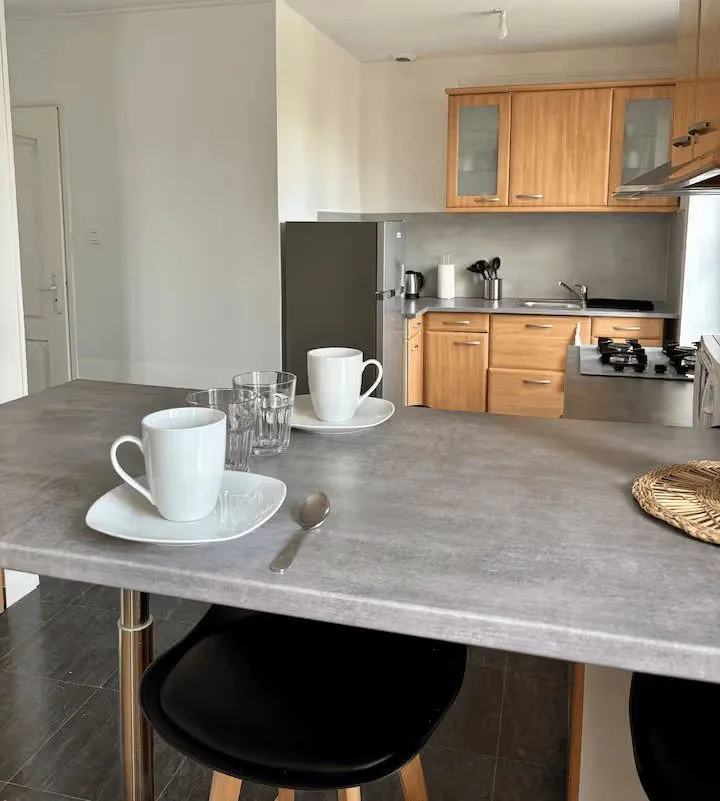 Coin repas avec plan bar, tasses et tabouret.