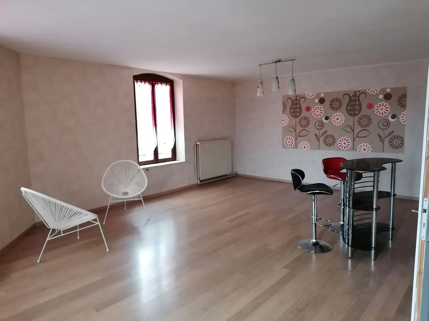 Pièce vide au parquet clair avec papier peint à motifs et bureau.