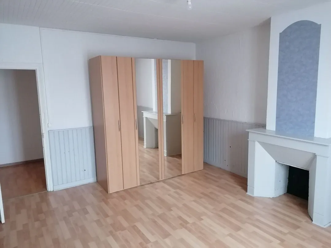 Pièce claire avec armoire en bois et niche maçonnée.