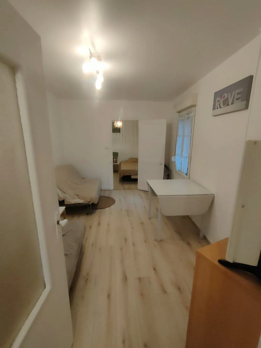 Le séjour en cours d'aménagement, vue vers le coin nuit, mobilier encore bâché.