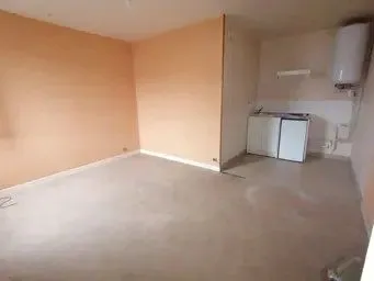 Pièce vide à la moquette usée et aux murs saumon.