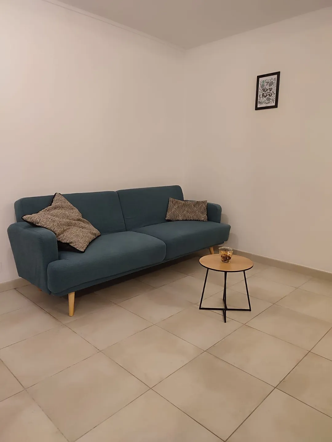 Canapé bleu-vert et table basse ronde dans la pièce à vivre.