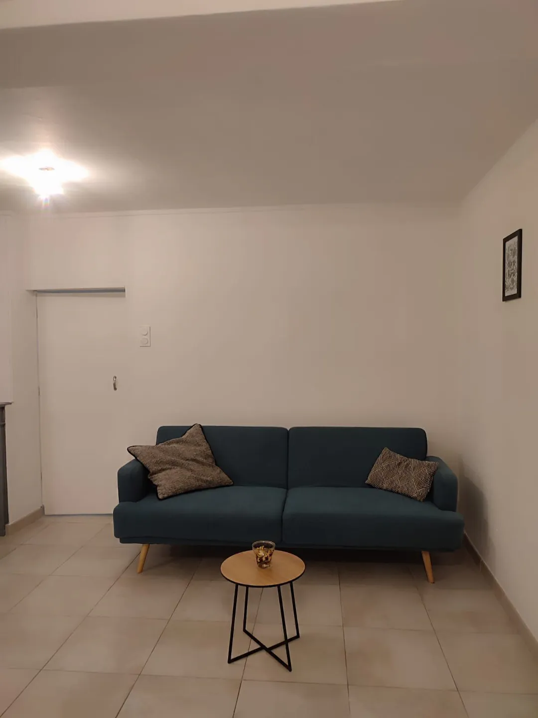 La pièce à vivre vue depuis la porte, canapé et table basse.