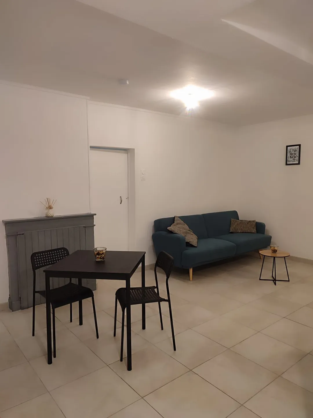Table de repas, chaises et buffet, canapé à l'arrière-plan.