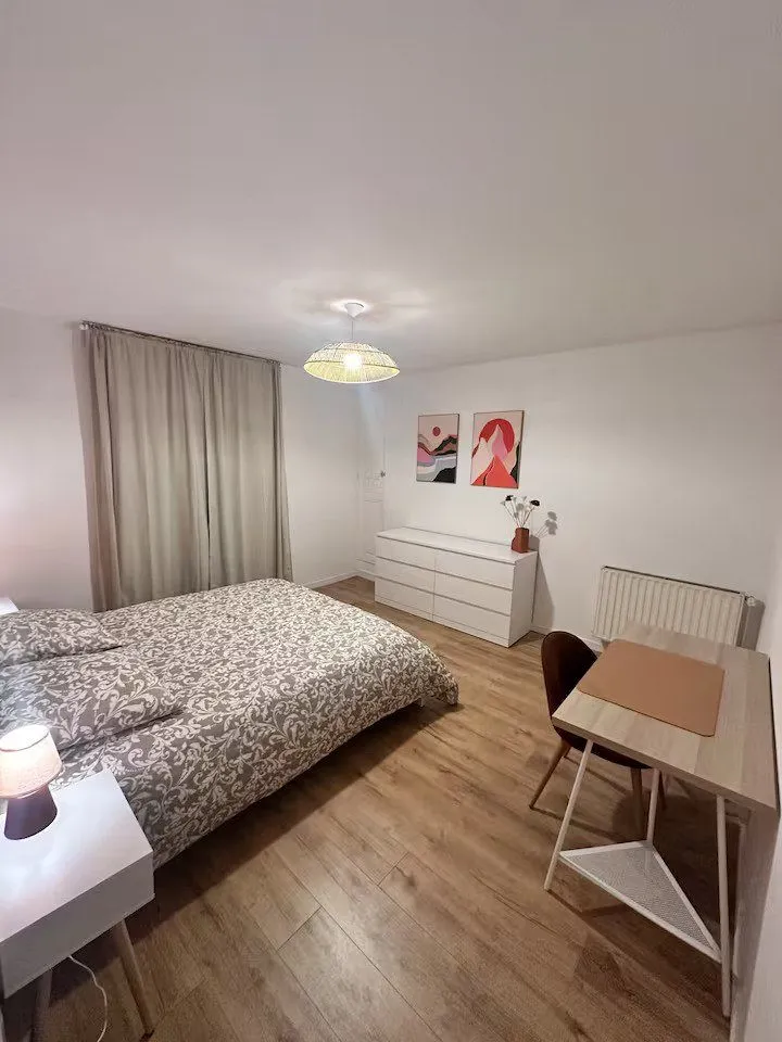 Chambre avec lit simple, commode, bureau et chaise.