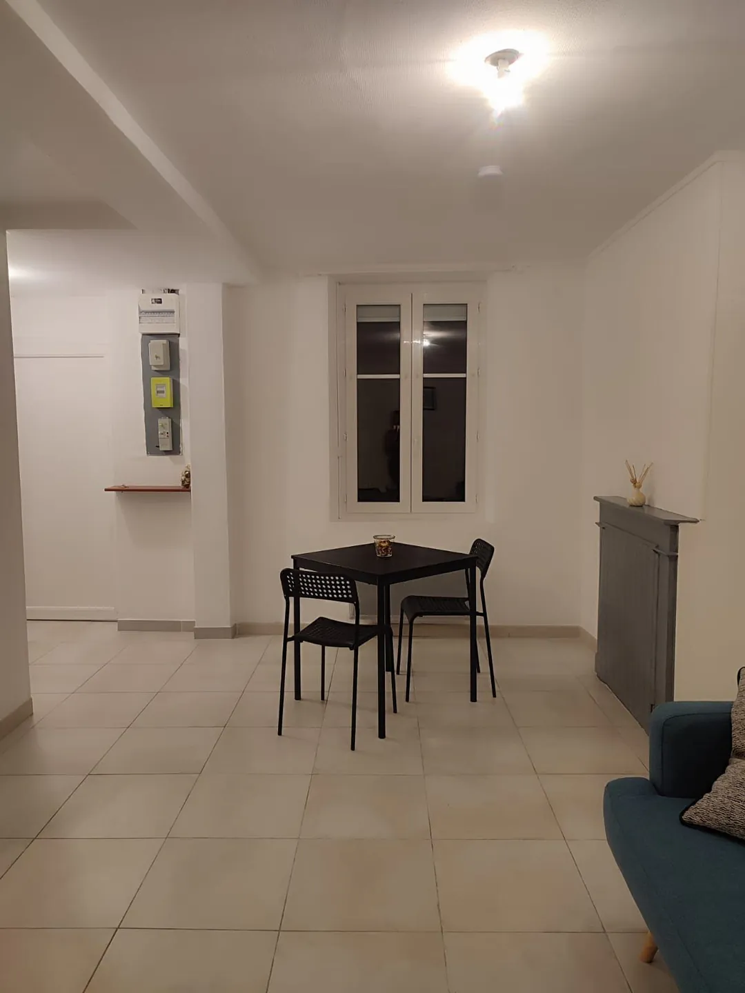 La pièce à vivre traversante, fenêtre au fond et buffet gris.