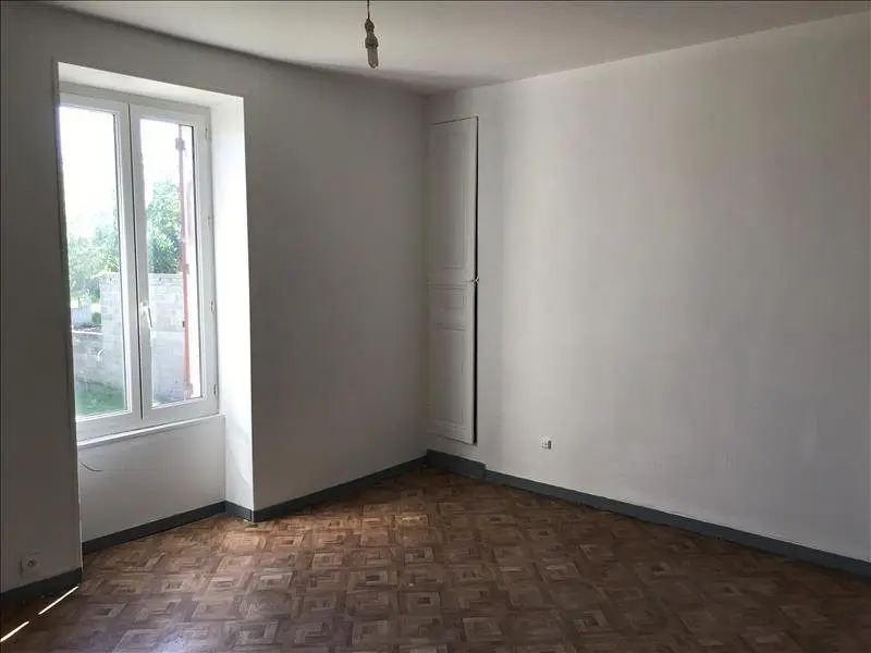 Le T4 de Lucille et Jonathan à la visite : pièce vide au parquet ancien, murs blancs et fenêtre à deux battants.