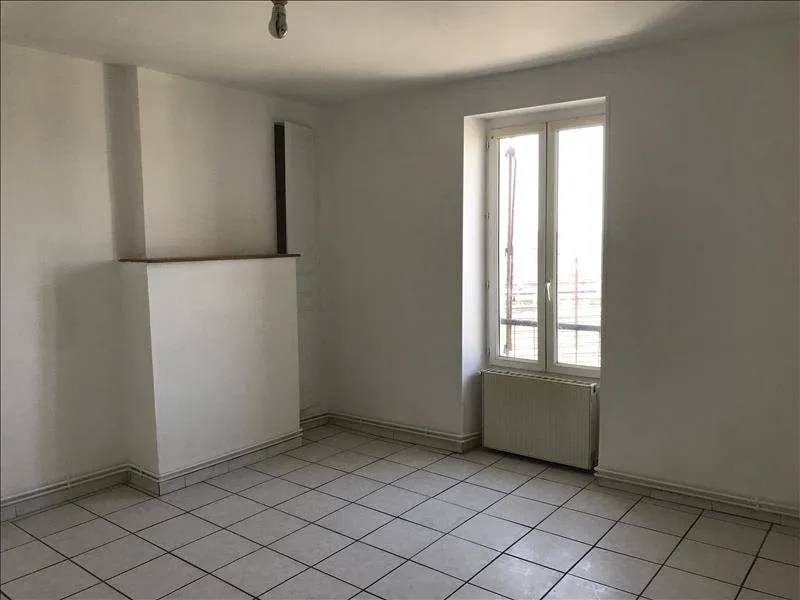 Pièce vide carrelée avec fenêtre et porte-fenêtre.