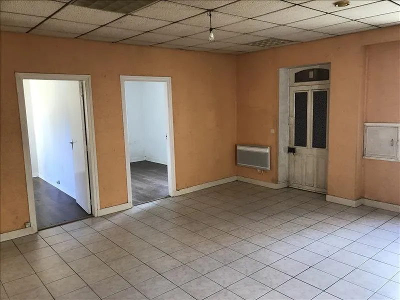 Le salon vu vers les portes, murs ocre et plinthes bois.
