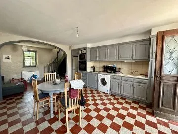 Cuisine grise et coin repas, carrelage en damier rouge et blanc.
