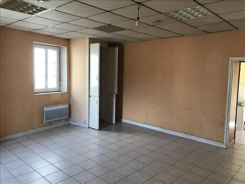 Angle du salon d'origine, radiateur et porte de la cuisine.